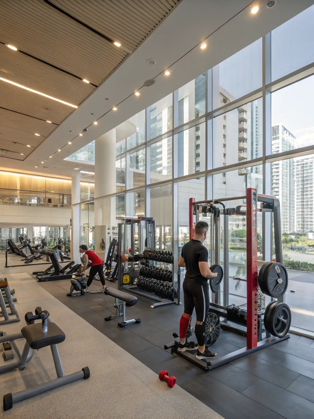 A brightly lit, modern fitness center with state-of-the-art equipment, including treadmills, elliptical machines, and weightlifting stations, showcasing the health and wellness amenities at Enwan Residance.